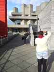 Woman demonstrating Dancer in front of concrete building