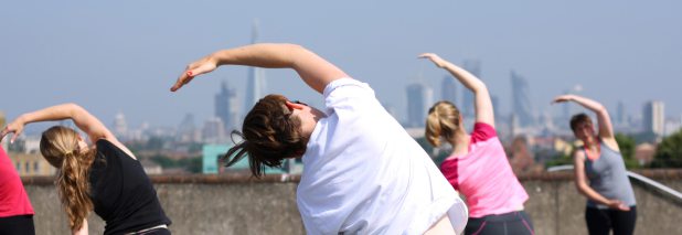 Students doing the side bend from the Dru Yoga EBR1 sequence on a rooftop in Peckham